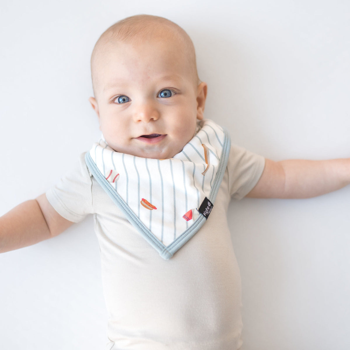 Baby wearing a striped bib with a plain background