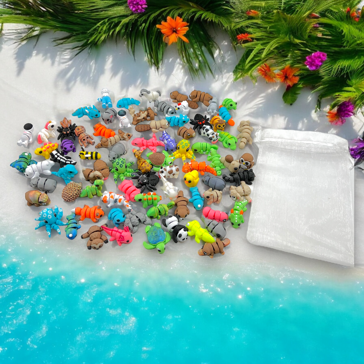 Assorted small animal figurines on a white surface with greenery and flowers in the background