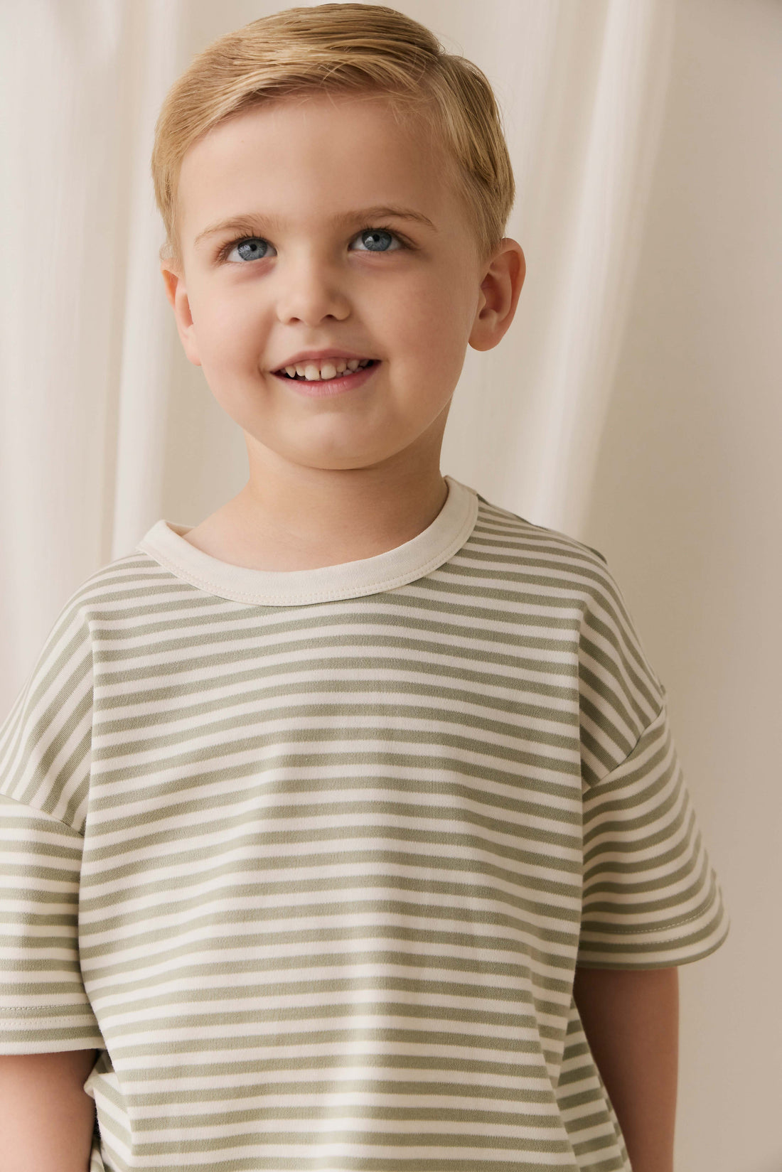 Young boy wearing a striped shirt against a plain background