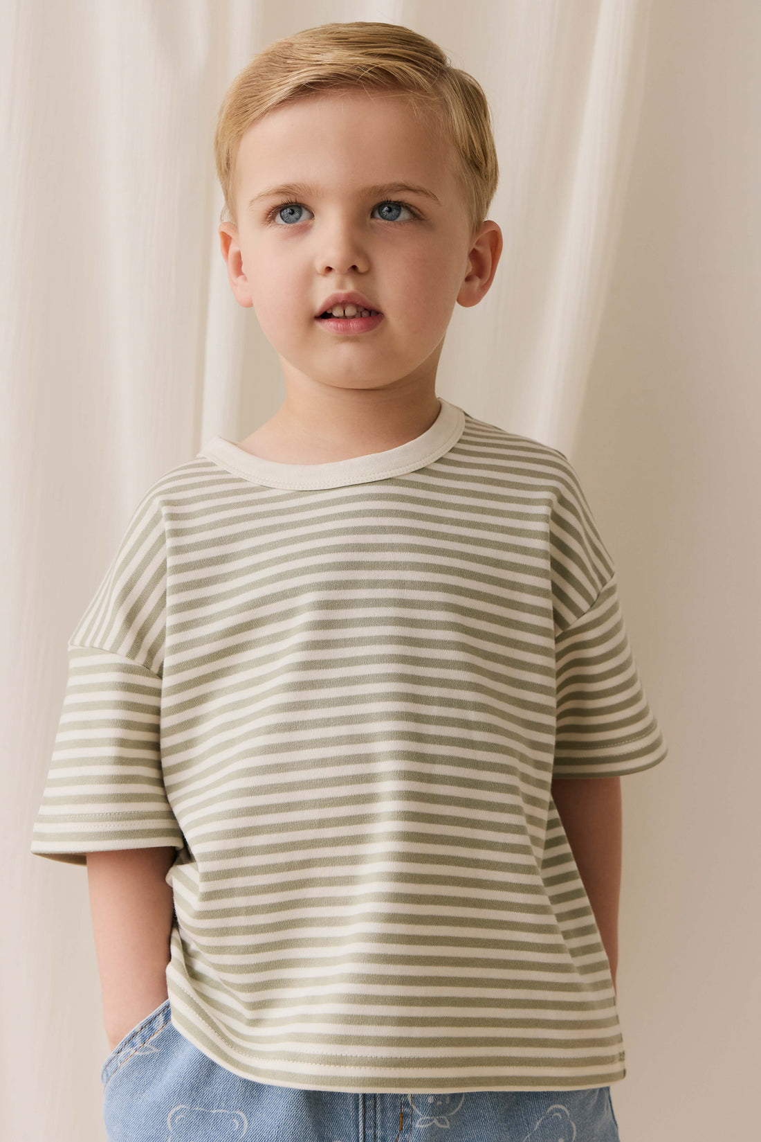 Young child wearing a striped shirt against a neutral background
