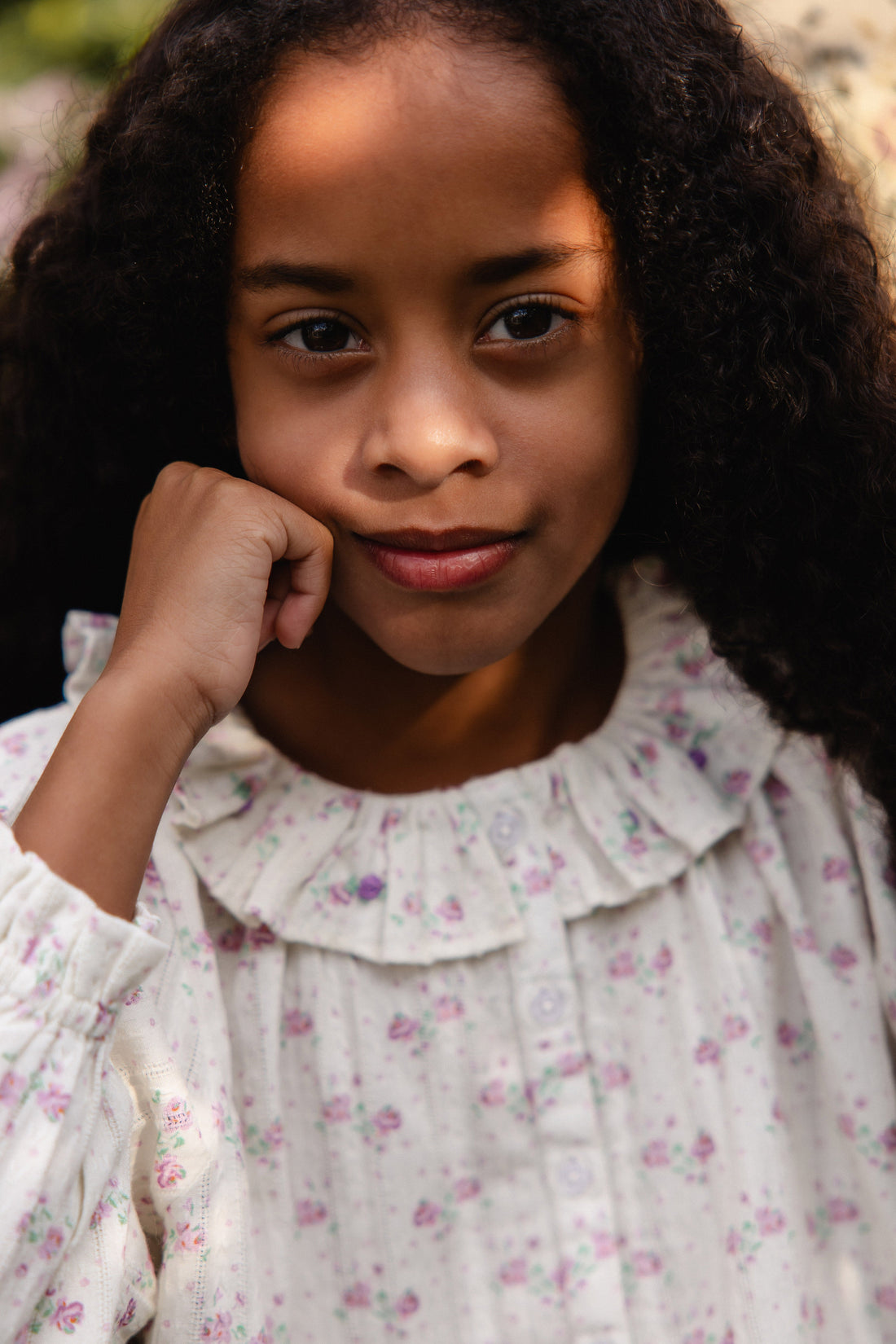 Young girl wearing a floral blouse.