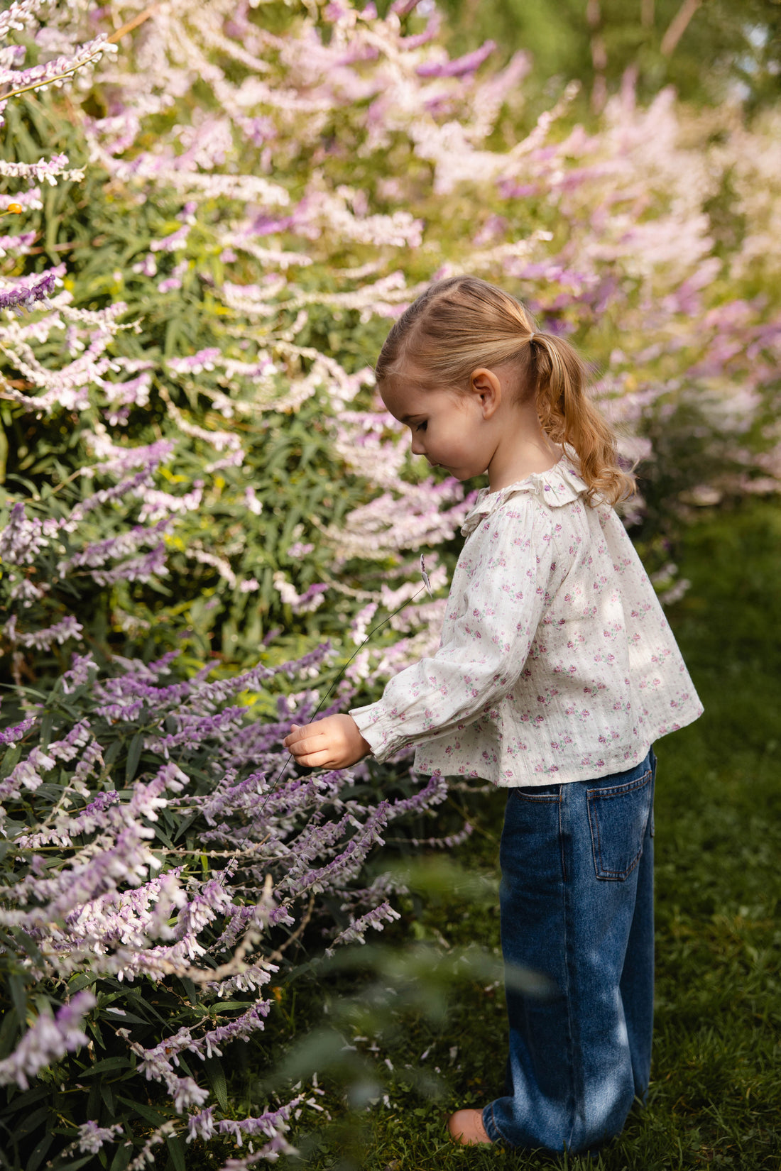 Young girl standing in a garden with lavender plants