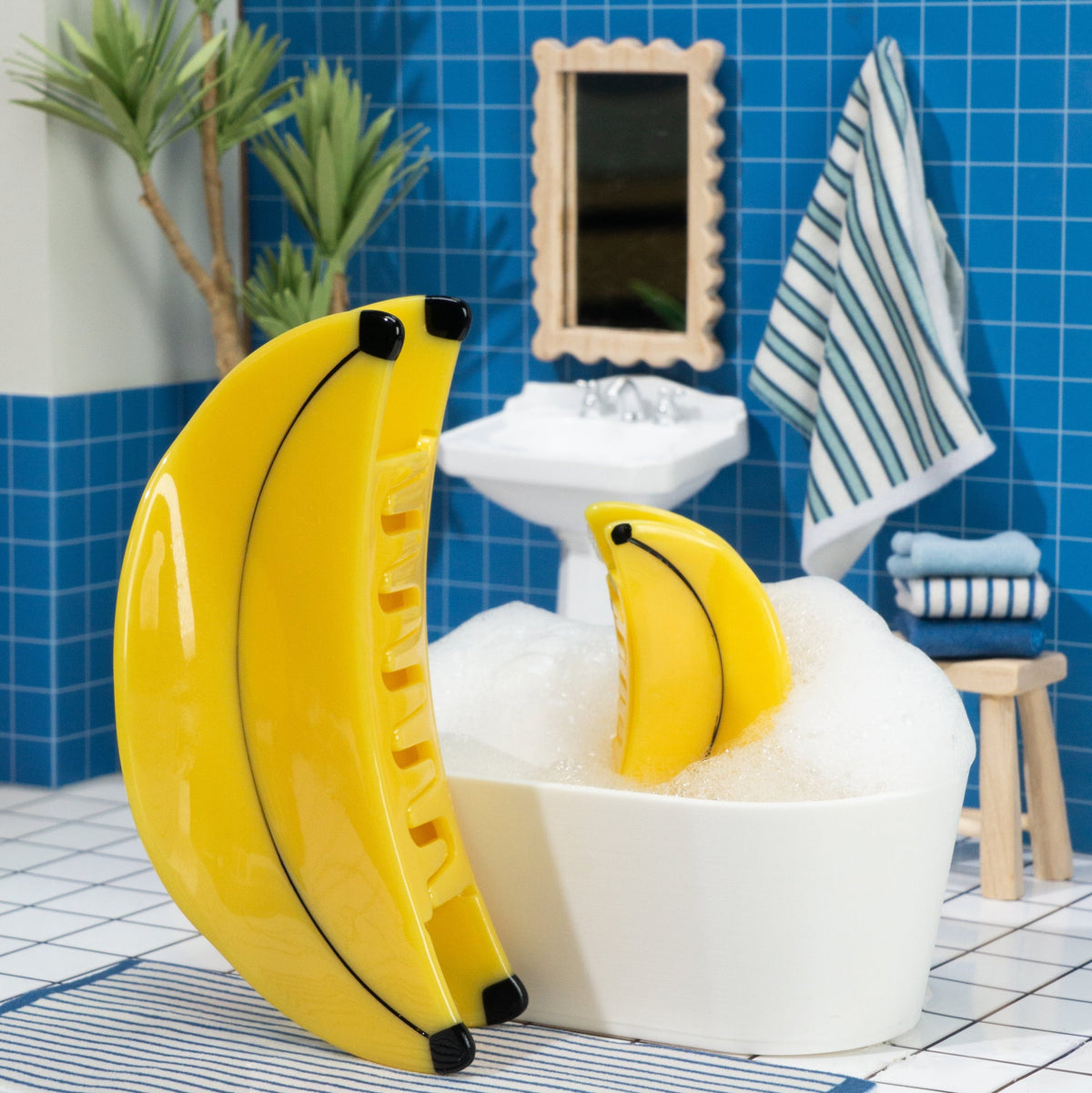 Bathroom with blue tiled wall, white bathtub, and inflatable banana-shaped pool float.