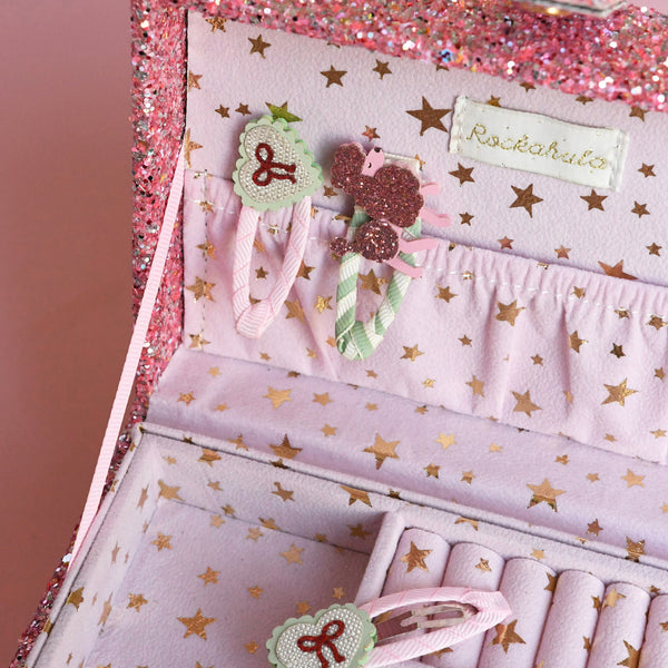 Set of hair accessories with decorative packaging featuring star patterns and a brand name.