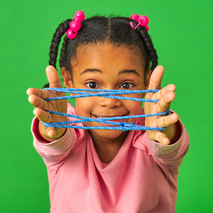 Child holding blue slime in front of a green background
