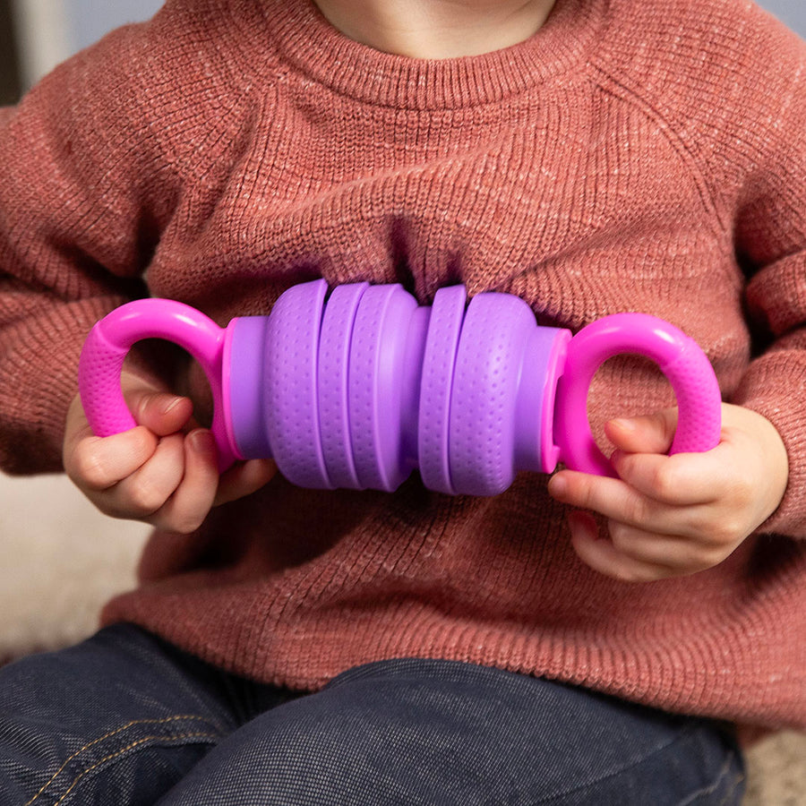 Child holding a purple and pink textured object