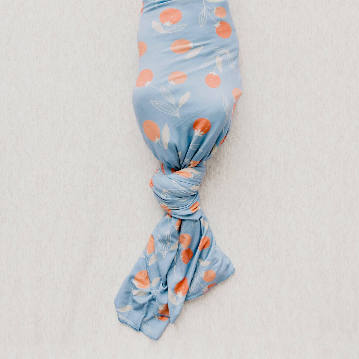 Blue fabric swaddle with floral pattern on a light gray background