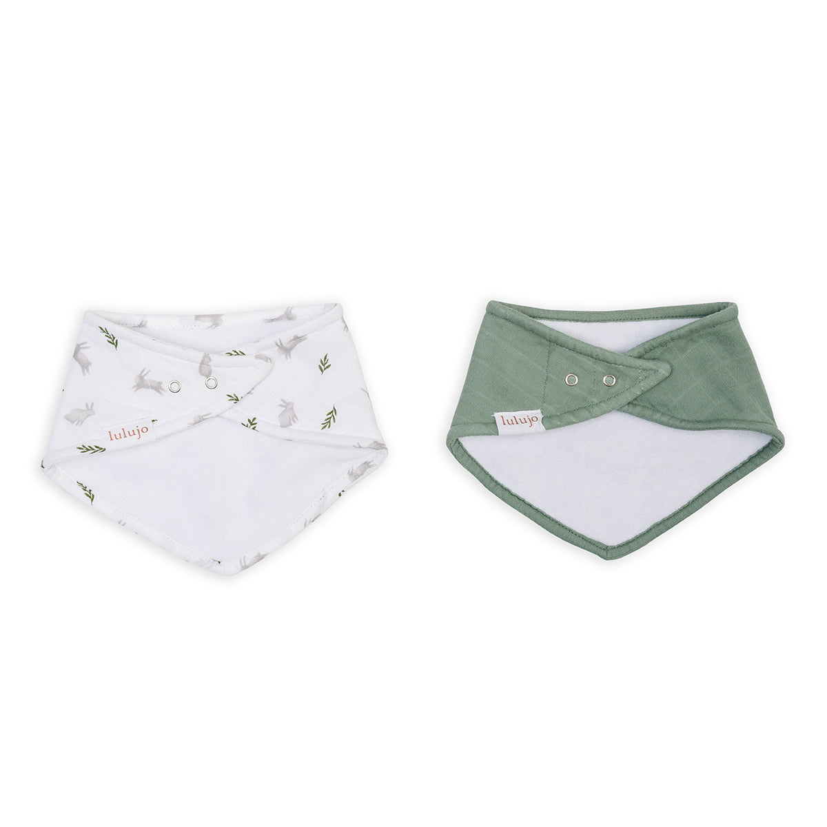 Two baby bibs, one white with green leaf pattern and the other green with white center, on a white background.