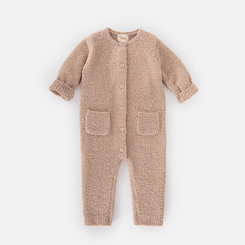 A soft, long-sleeve fuzzy romper in a warm pecan brown color by 7AM Enfant, featuring a round neckline, a full-length center button closure, ribbed cuffs and ankles, and two front pockets, laid flat on a white background.