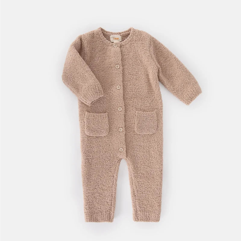 A soft, long-sleeve fuzzy romper in a warm pecan brown color by 7AM Enfant, featuring a round neckline, a full-length center button closure, ribbed cuffs and ankles, and two front pockets, laid flat on a white background.