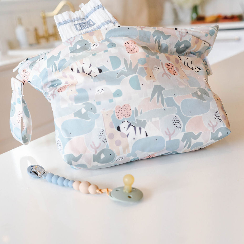 Patterned diaper bag with a pacifier on a white surface