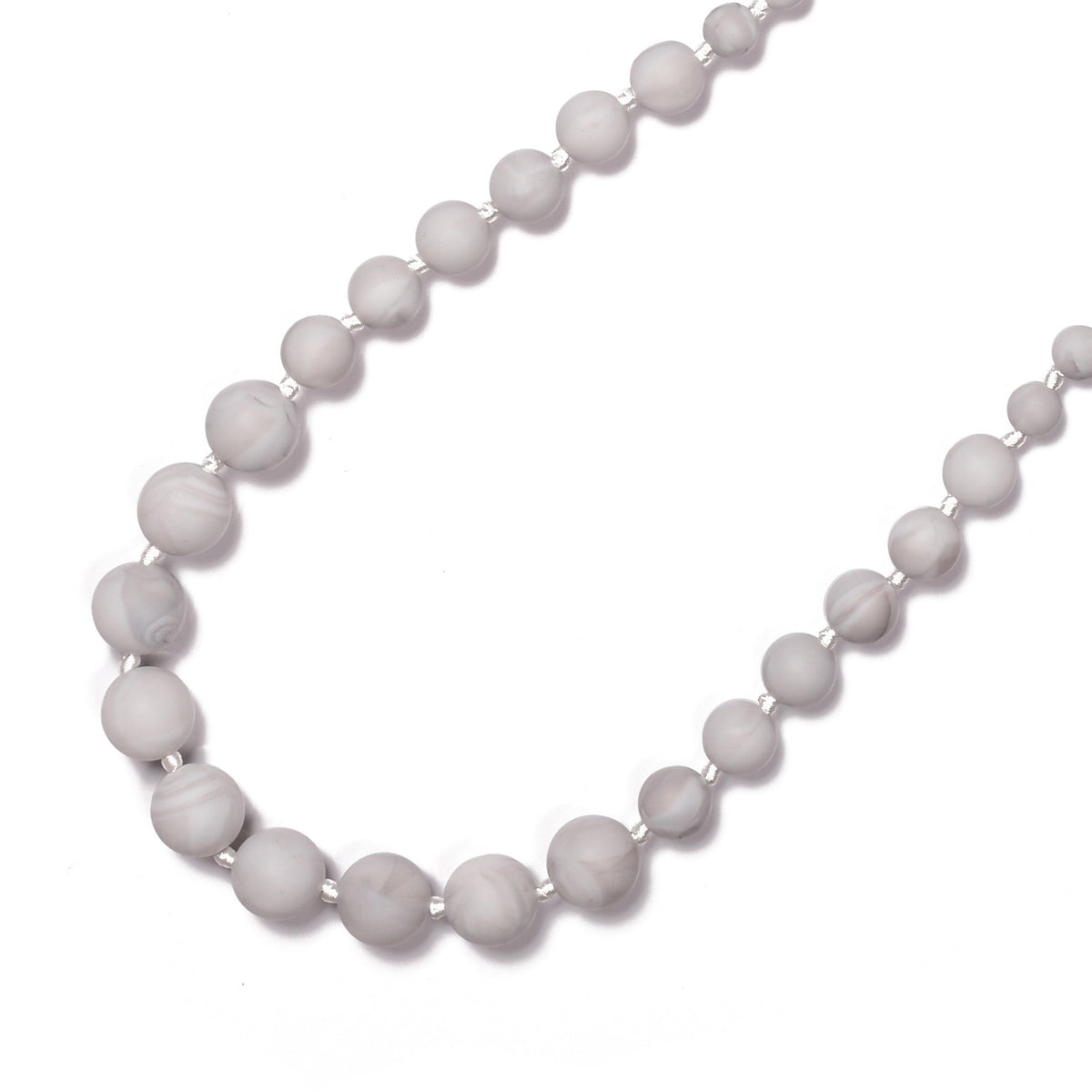 White beaded necklace on a white background