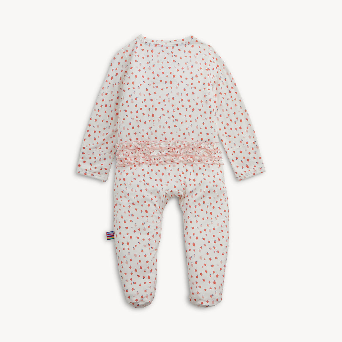 A baby footed sleeper with long sleeves and an all-over small red and green floral print on a white background, featuring a pink ruffle detail at the waist.