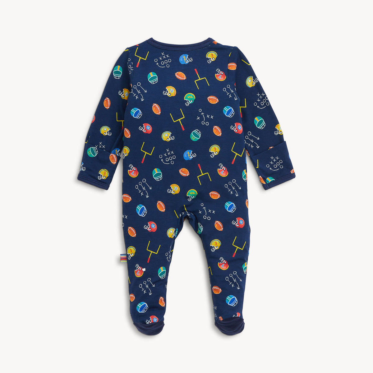 A baby footed one-piece sleeper in navy blue with a colorful sports-themed print of football helmets, footballs, hoops, and words like 'catch', 'run', and 'score', shown flat on a light gray background.