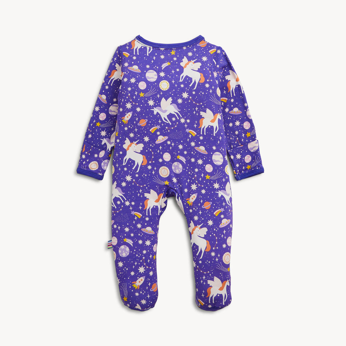A baby footed one-piece sleeper in purple with a whimsical space print featuring white unicorns, fairies, stars, planets, and rockets, displayed flat against a light off-white background.