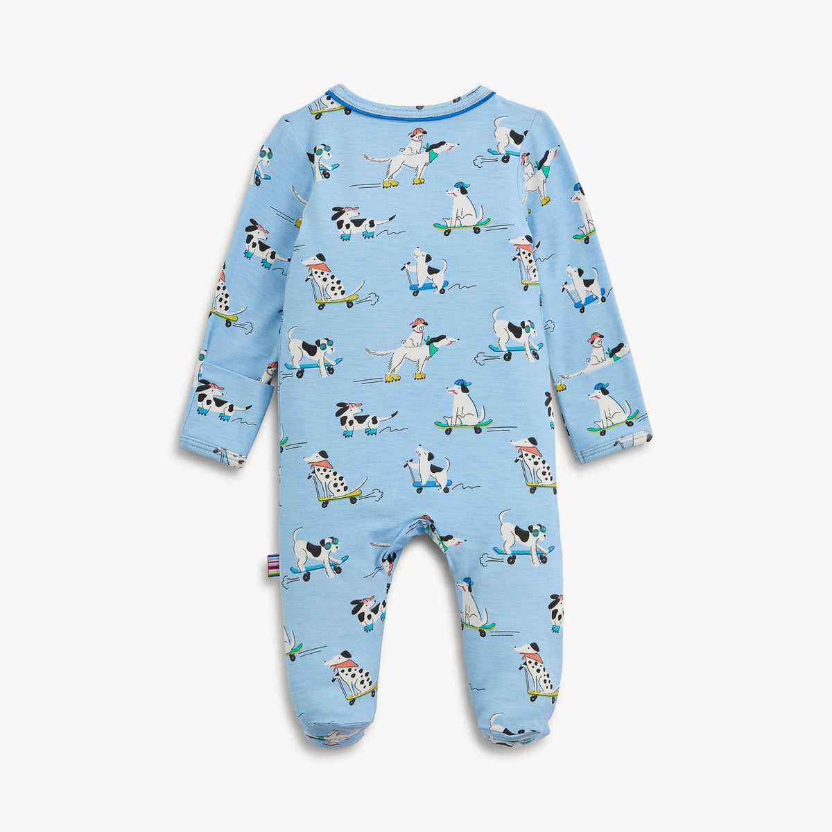 A baby's footed long-sleeve jumpsuit in light blue, featuring an all-over print of cartoon dogs in various sports poses on a plain off-white background.