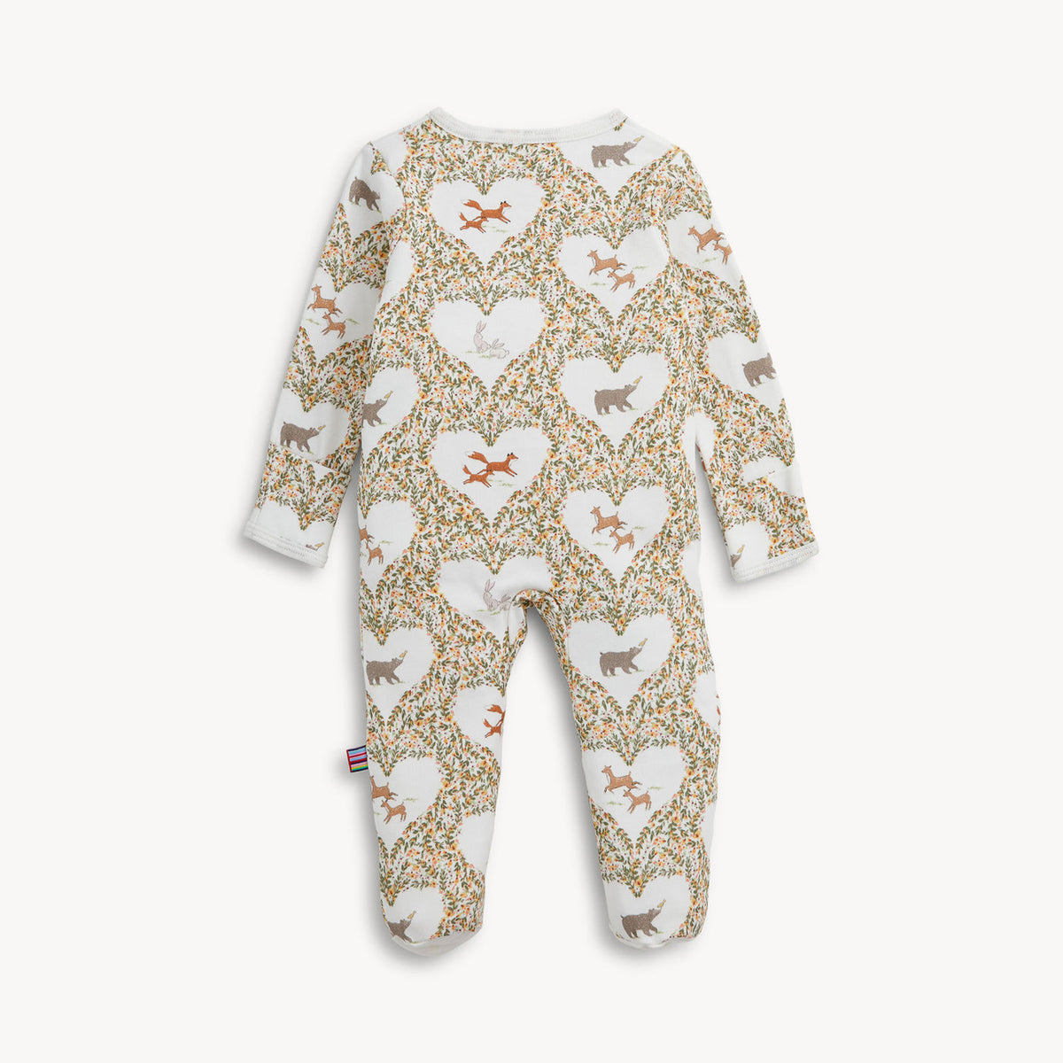 A baby footed one-piece jumpsuit with a long-sleeve design, featuring an all-over pattern of white hearts filled with small dog silhouettes and surrounded by a beige and green floral trellis. The jumpsuit is shown flat against a light off-white background.