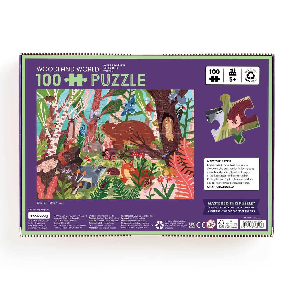 Back of the product box for the Woodland World 100 Piece Puzzle by Mudpuppy, showing the puzzle illustration, artist bio, and a preview of puzzle pieces against a purple background.