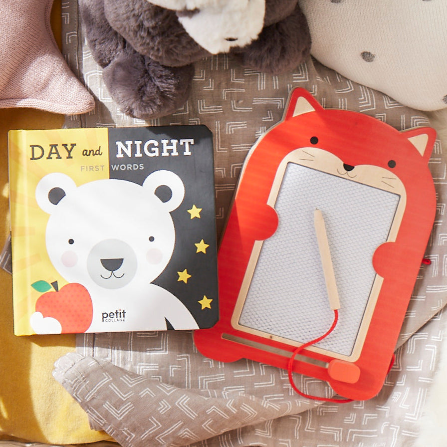 Children's books titled 'Day' and 'Night' with a fox-themed book on a soft surface.