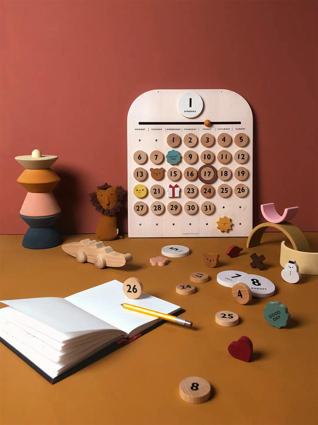 Calendar with wooden numbers and toys on a warm-toned surface
