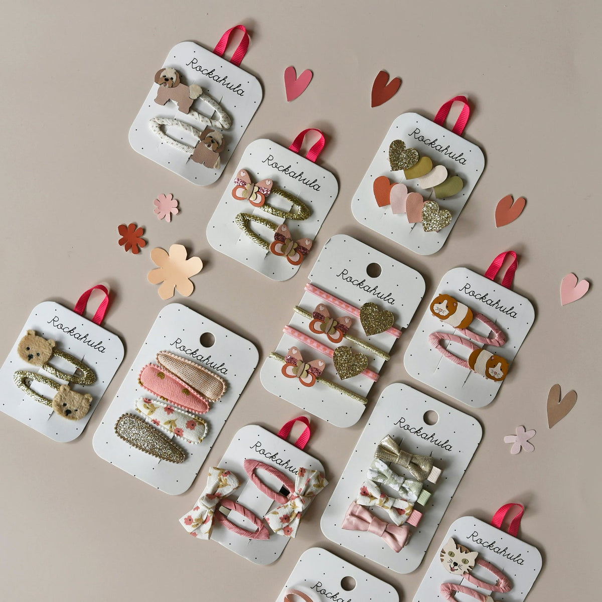 Collection of hair clips on display cards with decorative elements on a beige background