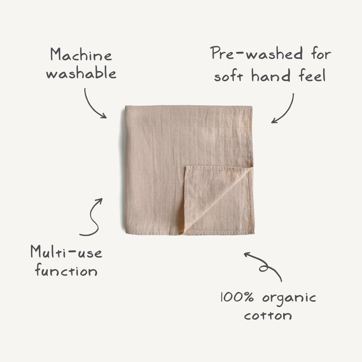 Folded beige towel with text describing its features on a white background
