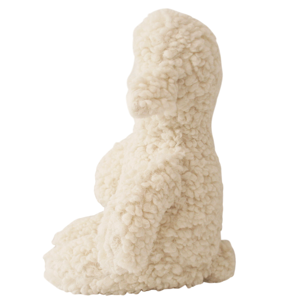 White sheepskin dog-shaped cushion on a white background