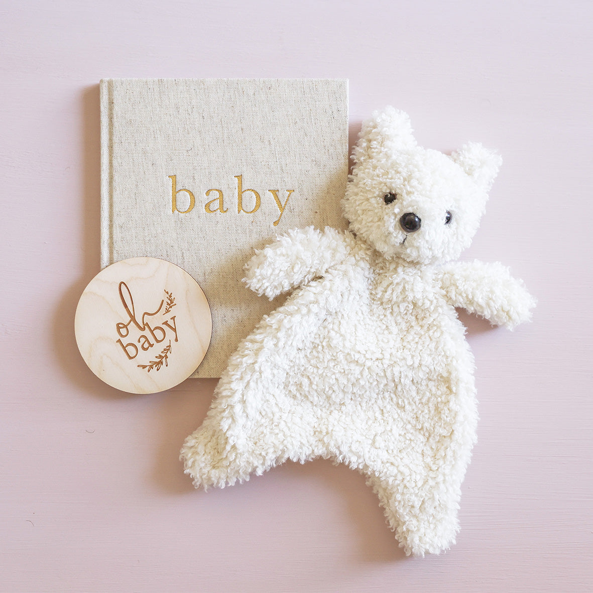 A cream-colored, curly teddy bear plush toy with small black embroidered eyes and nose on a white background.