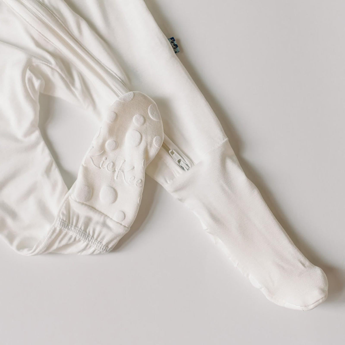 White baby socks with sole pattern on a light gray background