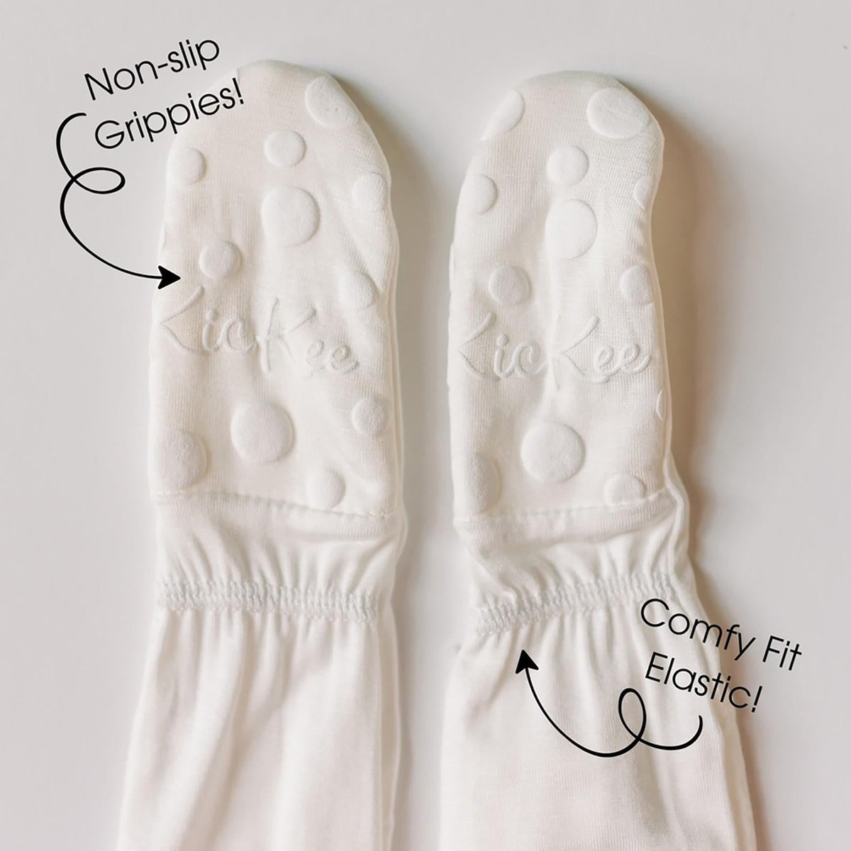 White socks with text highlighting 'Non-slip Grippies!' and 'Comfy Fit Elastic!' on a light gray background.
