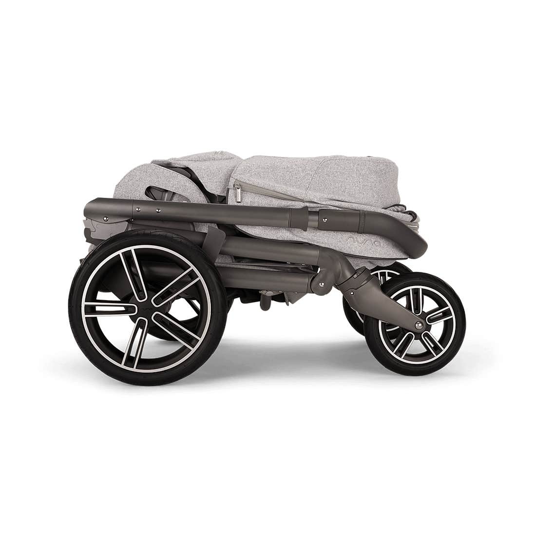 A folded stroller in a light gray heathered fabric with a dark gray frame and black wheels, shown from a side profile on a white background.