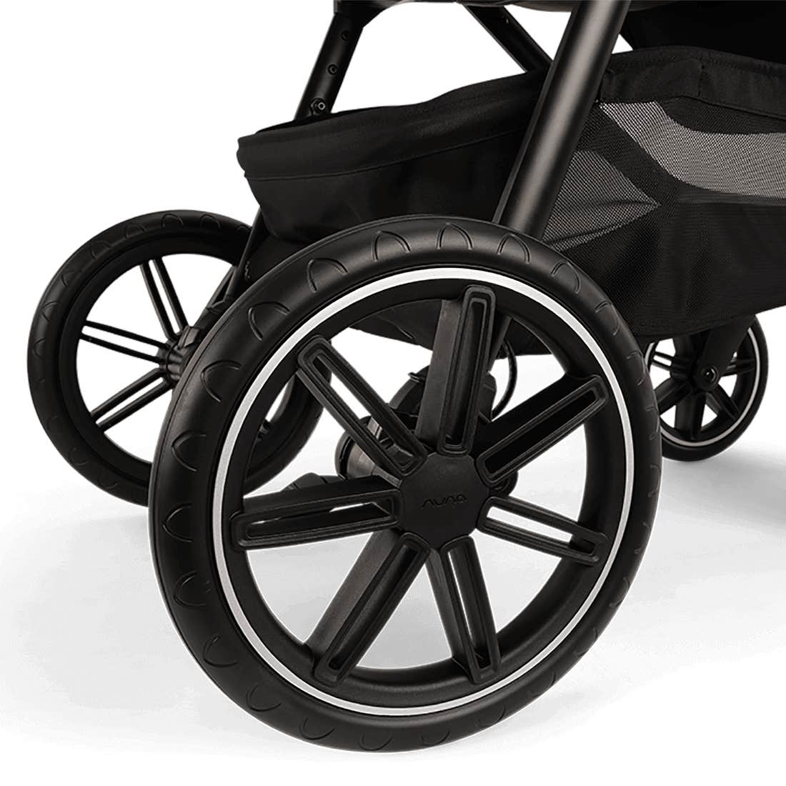 Close-up of a black stroller wheel on a white background