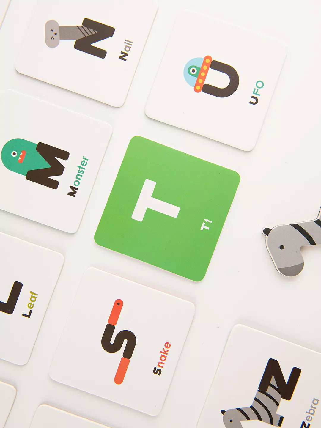Educational card game with alphabet cards and animal illustrations on a white background