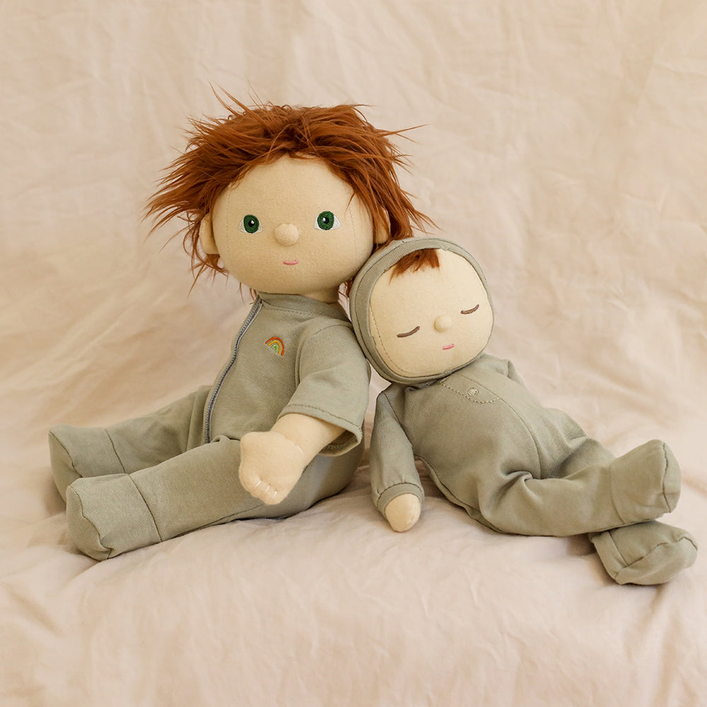Two dolls in matching outfits sitting on a soft surface