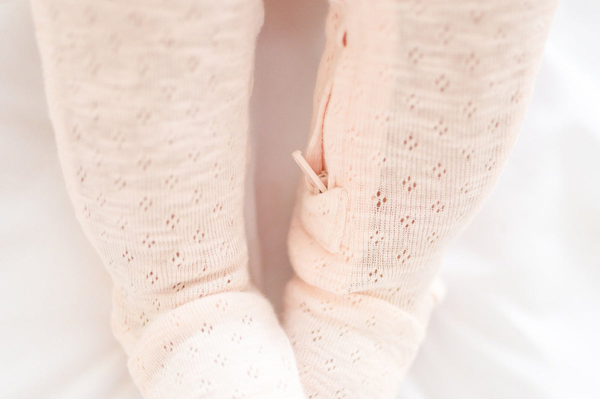 Close-up of a baby's feet in pink socks on a light background