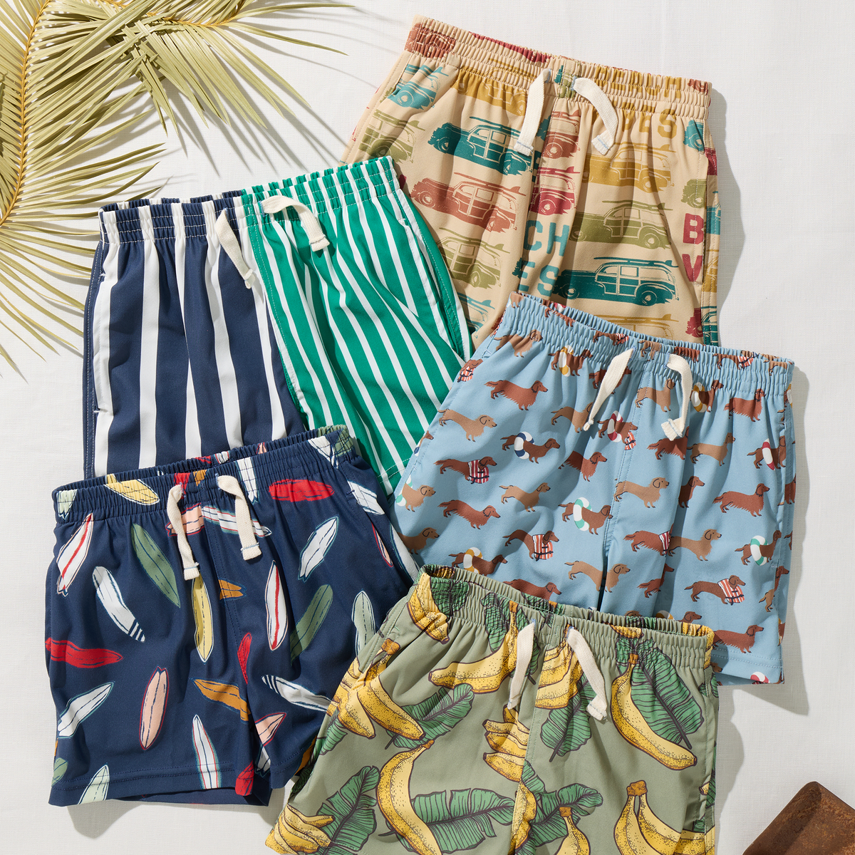 Collection of colorful children's shorts with various patterns on a white background.