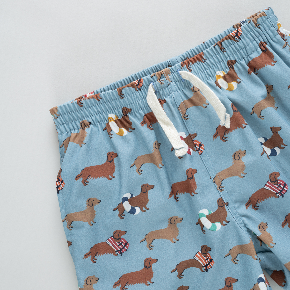 Blue boxer briefs with dachshund dog pattern on a light gray background
