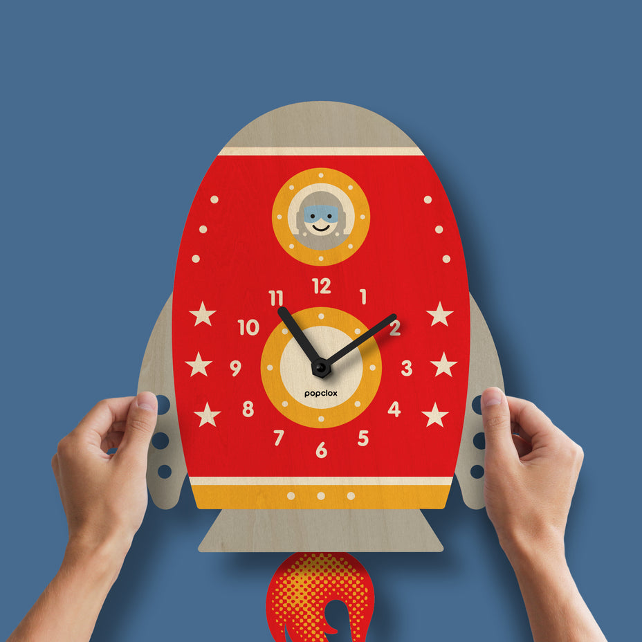 Rocket-shaped clock with a smiley face on a blue background