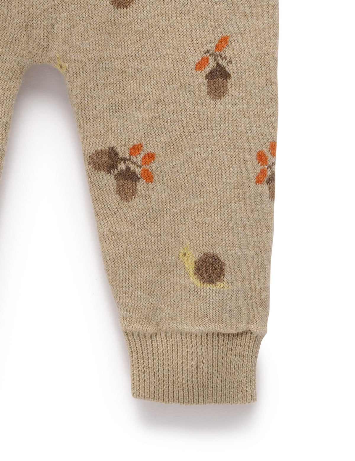 Beige knitted pants with autumn-themed patterns on a white background