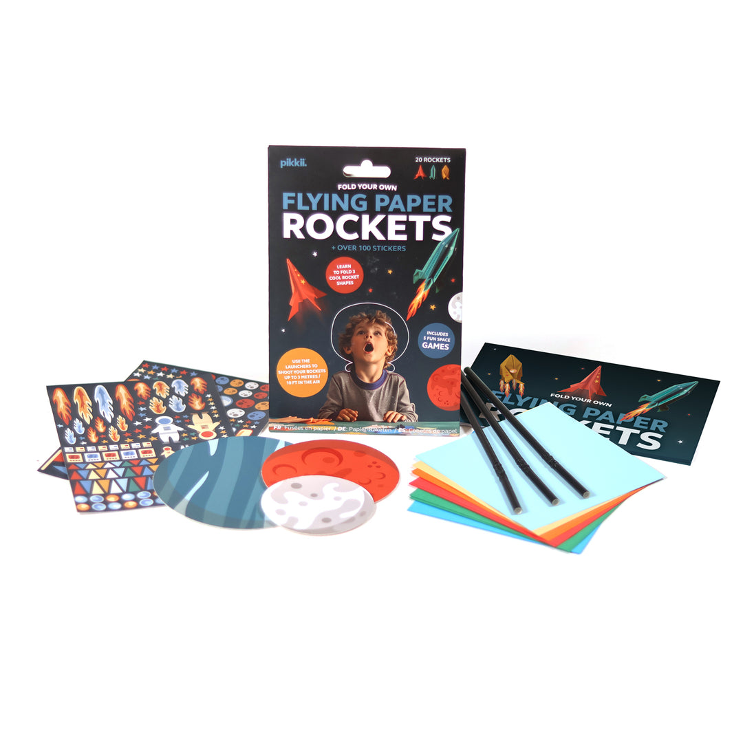 Flying paper rockets kit with book, markers, and colorful paper on a white background