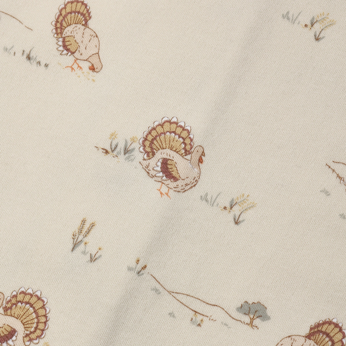 Fabric with charming tiny illustrated turkeys scattered across a soft cream background.