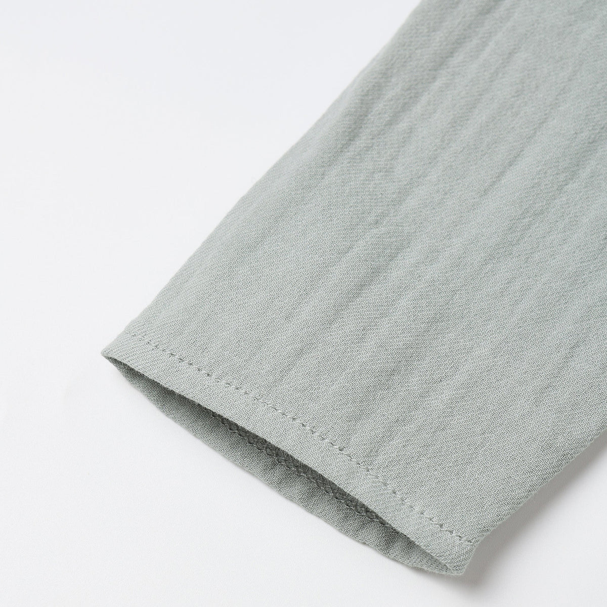 Close-up of a light gray fabric edge on a white background