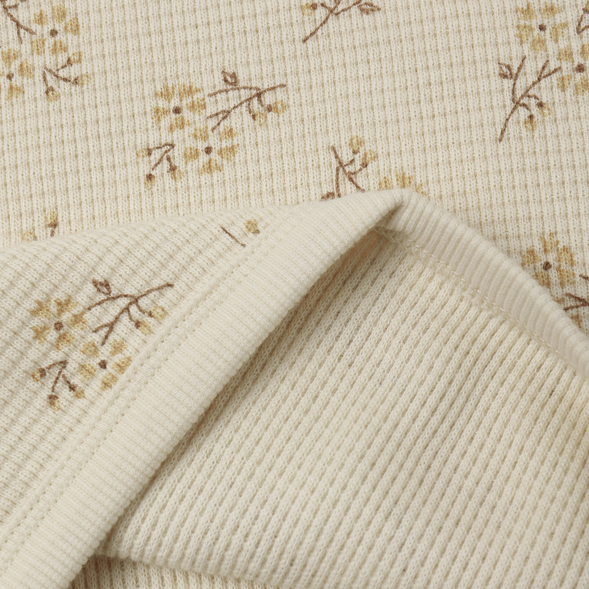 An off-white ribbed fabric with a delicate yellow floral ditsy print from Rylee + Cru.