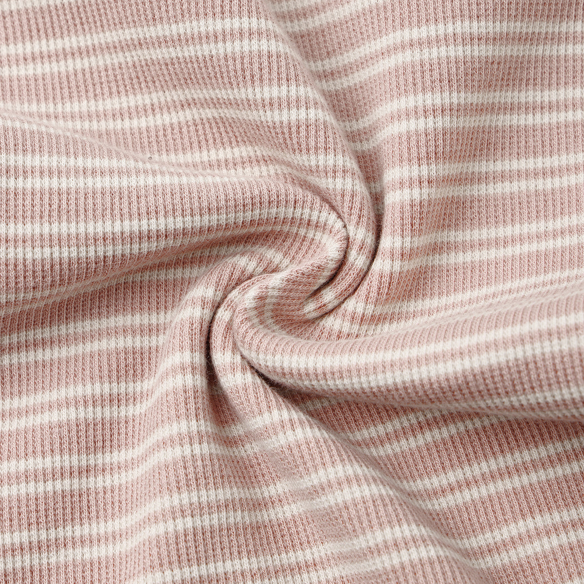 A close-up of a soft knit fabric with a dusty pink and white horizontal stripe pattern, arranged in a central swirl to highlight its texture and drape.