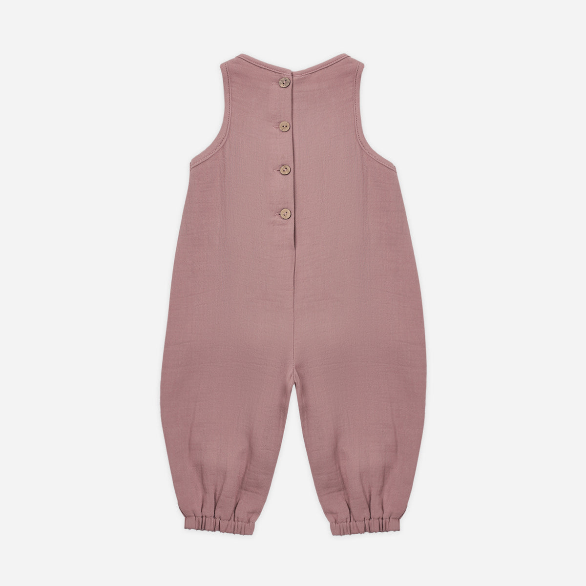 A sleeveless dusty rose baby jumpsuit with a button-up back, photographed flat against a light gray background.
