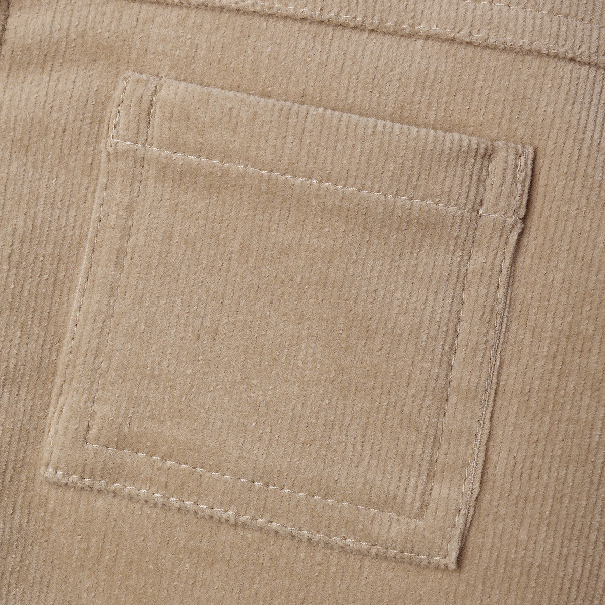 Close-up detail of the front patch pocket on the Ezrah Jacket in latte corduroy by Quincy Mae.