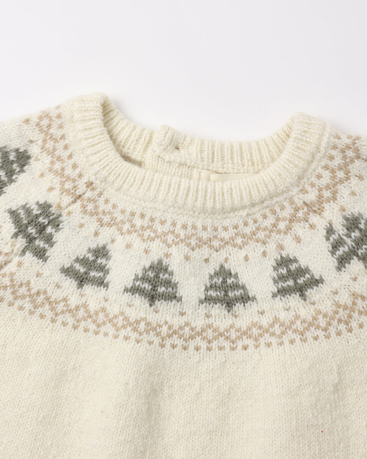 Cream-colored knit sweater featuring a close-up of a festive Fair Isle tree pattern along the neckline and shoulders.