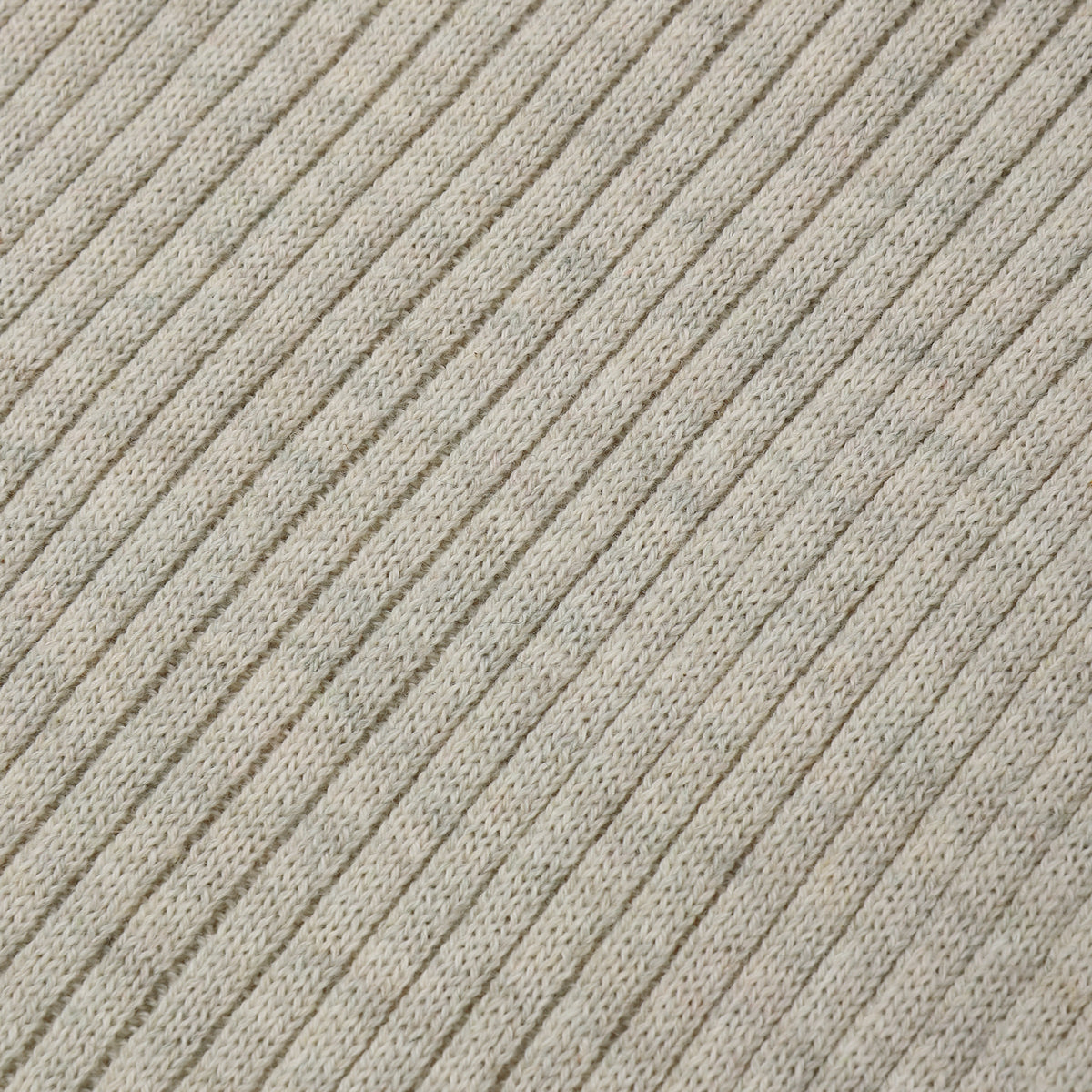 Close-up of a ribbed knit fabric in a light warm gray or oatmeal tone, showing the texture and pattern of the knit stitches.