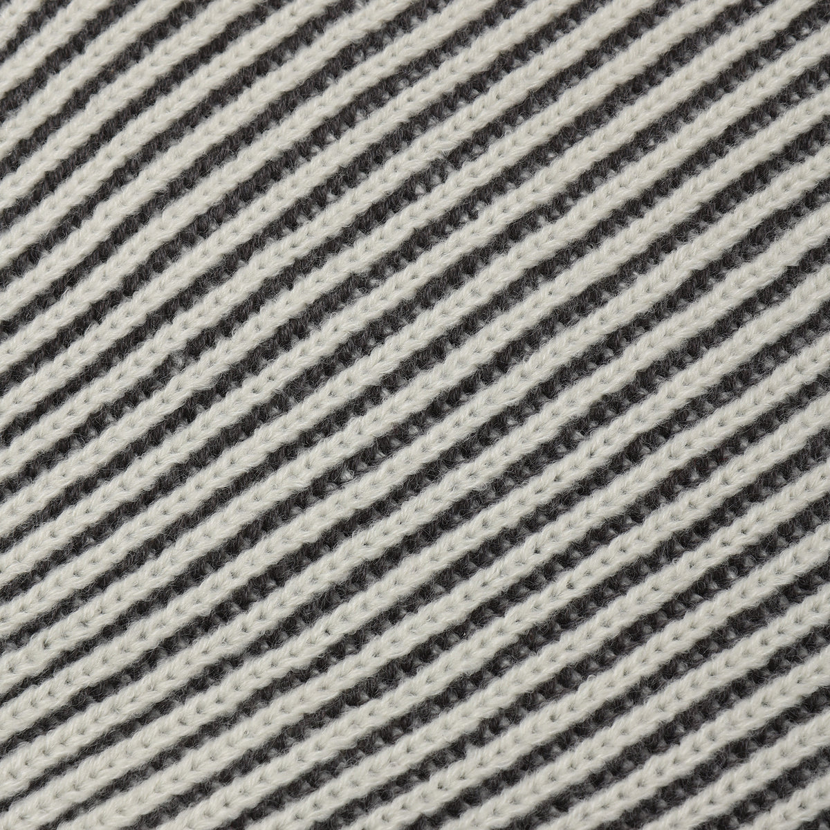 Close-up of a woven fabric with diagonal stripes in off-white and dark charcoal gray.