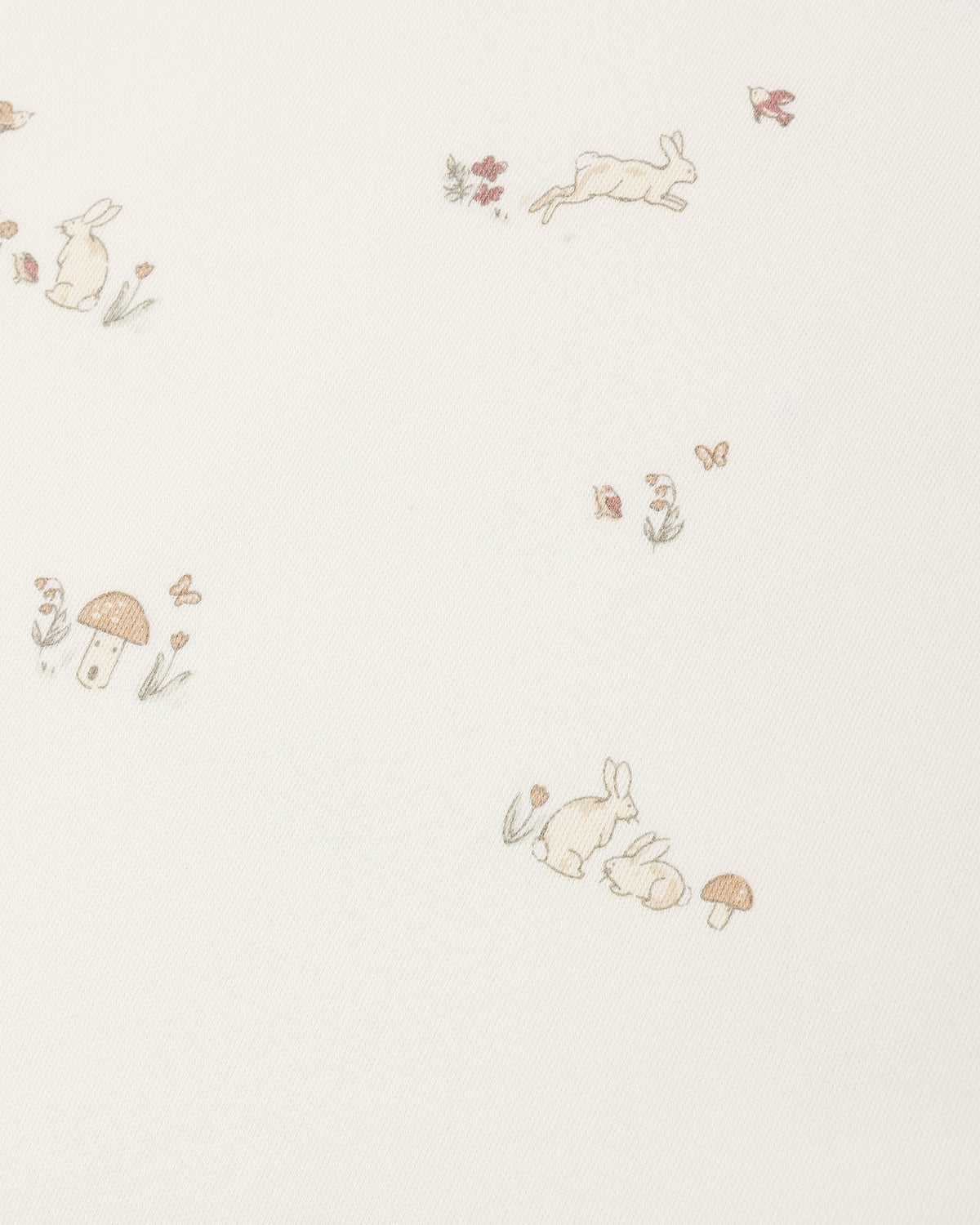 A close-up of a cream-colored fabric or wallpaper featuring a delicate, repeating pattern of small rabbits, mushrooms, flowers, and butterflies in soft beige, muted brown, and pale green tones.